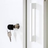 Zoom sur la serrure à clé de l'armoire en bois portes coulissantes, blanc
