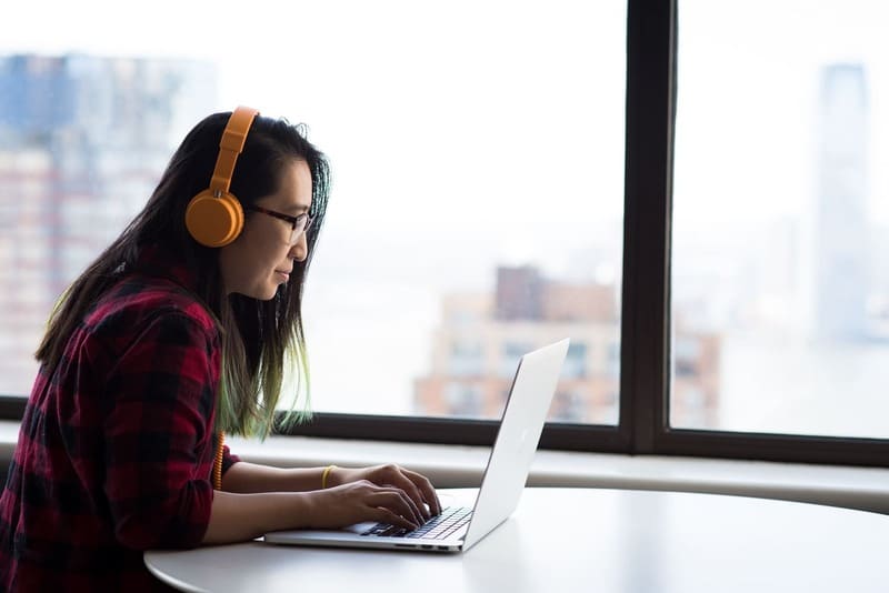 femme devant un ordinateur avec un casque audio